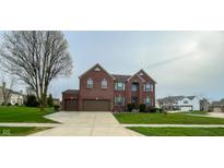 Charming two-story red brick home with a three-car garage and well-manicured front lawn at 6155 W Bayfront, McCordsville, IN 46055