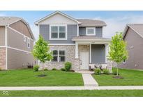 Charming two-story home featuring stone accents, blue siding, a well-manicured lawn, and sidewalk at 6460 Wasco Dr, Whitestown, IN 46075