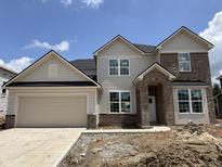Charming two-story home with attached two car garage featuring neutral siding and brick accents at 7239 Barrett Dr, Brownsburg, IN 46112