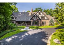 Charming Tudor home with a landscaped front yard and a circular driveway at 7406 N Washington Blvd, Indianapolis, IN 46240