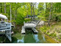 Waterfront property with private boat dock, boat slip, and steps leading to the wooded backyard at 7595 Heather Dr, Nineveh, IN 46164