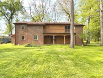 Spacious brick two-story home featuring a second story balcony overlooking a large yard at 830 Millerwood Dr, Lebanon, IN 46052