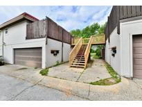 A two-story home featuring a garage and elevated wooden staircase leading to an upper entrance at 8360 Paso Del Norte Ct, Indianapolis, IN 46227