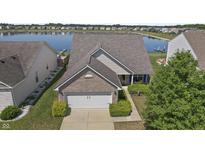 Charming brick home boasts a well-manicured lawn and a tranquil lake view, enhancing its curb appeal at 8644 S Tibbs Ave, Indianapolis, IN 46217