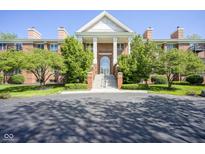 Elegant brick building with a grand entrance featuring white columns and manicured landscaping at 8751 Jaffa Court East Dr # Apt 32, Indianapolis, IN 46260