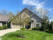 Charming home with stone and siding exterior, well-manicured lawn, and attached two-car garage at 9789 Rue Renee Ln, McCordsville, IN 46055