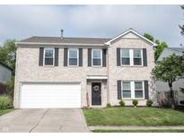 Charming two-story home featuring a brick facade, attached garage and manicured lawn at 10266 Hatherley Way, Fishers, IN 46037