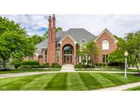 Beautiful brick home with manicured lawn, arched windows, and a welcoming entrance at 10554 Hyde Park, Carmel, IN 46032