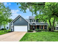 Charming two-story home featuring a covered front porch, a spacious lawn, and an attached two-car garage at 10906 Camden Ct, Fishers, IN 46038
