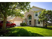 Attractive home exterior with a well-maintained lawn, tree, and a two-car garage at 11727 Wedgeport Ln, Fishers, IN 46037