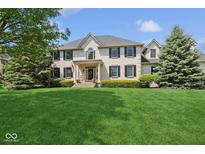 Stately two-story home featuring a well-manicured lawn and a classic brick facade with black shutters at 13868 Broad Mdw, Carmel, IN 46032