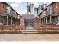 Charming brick facade with wrought iron fence and well-maintained flower beds at 1446 N Illinois St, Indianapolis, IN 46202