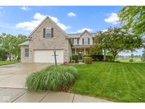 Charming two-story home with a well-manicured lawn, attached garage, and beautiful landscaping at 18711 Crestline Ct, Noblesville, IN 46060