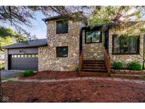 Charming stone-clad home with wooden steps leading to the entrance and an attached two-car garage at 1940 Stringtown Pike, Cicero, IN 46034