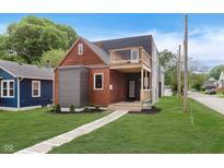 Beautiful two-story home with a modern design, a mix of wood, grey, and black finishes, a deck, and a well-kept lawn at 2302 S Pennsylvania St, Indianapolis, IN 46225