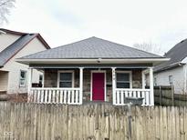 Charming home featuring a stone facade, inviting front porch with white railings and a vibrant red front door at 309 N Forest Ave, Indianapolis, IN 46201