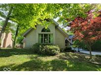 Charming exterior of a light brick home featuring mature landscaping and an arched window detail at 3917 Knoll Wood Ln, Anderson, IN 46011