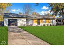 Charming single-story home with a well-manicured lawn and driveway leading to the garage at 4457 Campbell Ave, Indianapolis, IN 46226