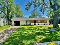 Charming single-story home with a well-manicured lawn, mature trees, and a welcoming front entrance at 4457 Campbell Ave, Indianapolis, IN 46226