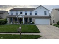 Charming two-story home featuring a well-manicured lawn, white picket fence, and a spacious two-car garage at 450 Columbia Ct, Greenwood, IN 46142