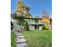 Charming home featuring a well-manicured lawn, stone accents, and a cozy second-story balcony at 5222 Nob Ln, Indianapolis, IN 46226