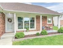 Charming brick home featuring a cozy covered front porch area and landscaped yard at 555 Echo Bend Blvd, Greenwood, IN 46142