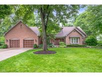 Charming brick home featuring a two-car garage and a lush green lawn at 6575 Robin Hood Dr, Indianapolis, IN 46227