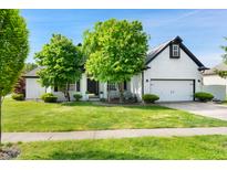 Charming home featuring a white brick exterior, well-manicured lawn, and an attached two-car garage at 6897 Abercon Trl, Noblesville, IN 46062