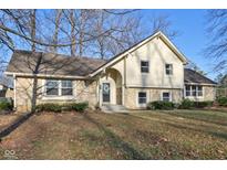 Charming exterior elevation of home showcasing stone accents, manicured lawn and inviting entryway at 7910 Teel Way, Indianapolis, IN 46256