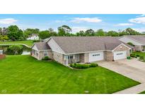Charming townhome with well-maintained landscaping, attached garage, and lovely pond views at 7937 Bentley Commons Dr, Indianapolis, IN 46259