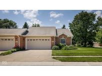 Charming brick home featuring a two-car garage and well-manicured lawn at 8133 Hazen Way, Indianapolis, IN 46216