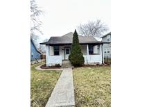Charming home featuring a stone walkway and an evergreen tree in the front yard at 834 N Temple Ave, Indianapolis, IN 46201