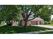 Charming brick two-story home with well-manicured lawn, mature trees, and a two-car garage at 8598 Lantern Farms Dr, Fishers, IN 46038