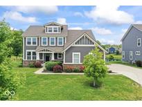 Charming two-story home with a beautifully landscaped front yard and classic architectural details at 12052 Northface Dr, Noblesville, IN 46060