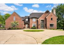 Stunning brick home featuring a circular driveway and beautiful landscaping at 12945 E 100 N, Columbus, IN 47203