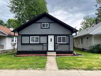 Charming exterior view of renovated home with gray siding, black trim, and manicured lawn at 1417 N Belleview Pl, Indianapolis, IN 46222