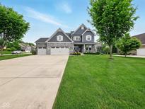Beautiful two-story home with a three-car garage and meticulously manicured lawn and landscaping at 165 N Bend Dr, Greenwood, IN 46142