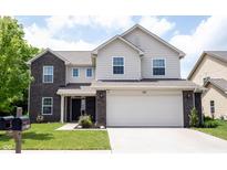 Charming two-story home with a two-car garage, landscaped yard, and a combination of brick and siding at 17696 Arryne E Dr, Noblesville, IN 46062