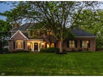 Charming brick home with a well-manicured lawn and mature tree, creating a picturesque curb appeal at 2055 Mulsanne Dr, Zionsville, IN 46077