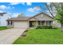 Charming single-story home featuring a well-maintained lawn, landscaping, and a two-car garage at 3214 Limber Pine Dr, Whiteland, IN 46184