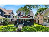 Inviting two-story home with a covered porch and a well-maintained front yard at 405 N Drexel Ave, Indianapolis, IN 46201