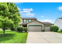 Charming two-story home with a three-car garage, well-manicured lawn, and mature tree at 5523 Gainesway Dr, Greenwood, IN 46142
