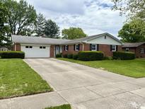 Charming brick ranch home featuring an attached two-car garage and well-manicured landscaping at 641 Lawndale Dr, Plainfield, IN 46168
