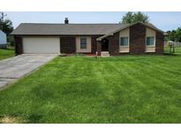 Charming brick home with a well-maintained lawn and attached two car garage at 8510 E Mcgregor Rd, Indianapolis, IN 46259