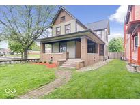 Inviting two-story home with a covered front porch and well-maintained lawn at 989 Woodruff Pl E Dr, Indianapolis, IN 46201