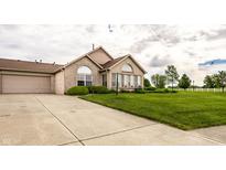 Charming brick home with well-manicured lawn, attached garage, and large windows at 11646 Winding Wood Dr, Indianapolis, IN 46235