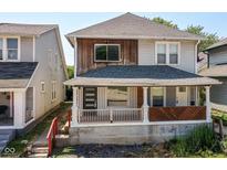 Charming two-story home featuring a cozy front porch with stylish design elements at 1212 S Senate Ave, Indianapolis, IN 46225