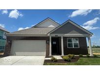 Charming single-story brick home featuring a two-car garage and neatly landscaped front yard at 1266 Foxtail Ln, Greenwood, IN 46143