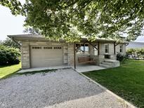Charming stone home featuring a one-car garage and a delightful porch swing at 1570 S Harriet St, Martinsville, IN 46151