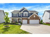 Inviting two-story home featuring a brick and siding facade, attached two-car garage, and well-manicured lawn at 15717 Hush Hickory, Westfield, IN 46074